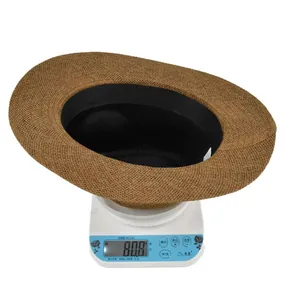 Detailed close-up of brown straw hat weave texture and interior sweatband on a scale
