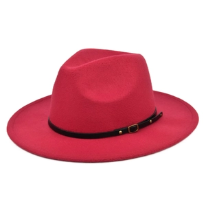 Detail of rose red felt fedora hat featuring black leather band and gold metal buckle