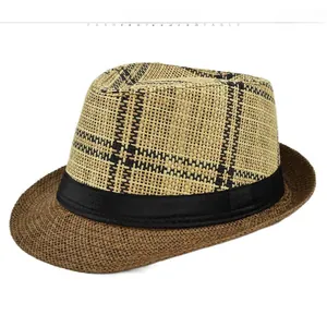 Detail of woven straw fedora hat featuring two-tone checkered texture and black ribbon band