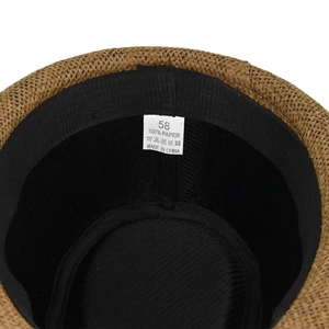 Macro detail of brown straw fedora interior showing sweatband and 100% paper material label