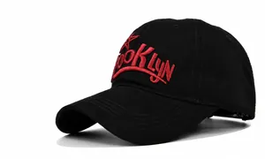 Close-up of red Brooklyn 3D embroidery on a classic black cotton baseball cap