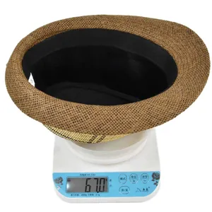 Detail view of a lightweight 67g woven straw jazz hat on a scale showing quality craftsmanship