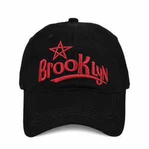 Detailed macro shot of red 3D Brooklyn embroidery on a black cotton baseball cap
