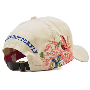 Close-up of butterfly embroidery with sequins and adjustable leather strap on beige cap