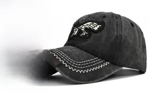 Detailed close-up of eagle embroidery and white zigzag stitching on a vintage baseball cap