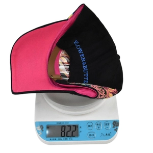 Detail of baseball cap showing weighing scale, flower embroidery and pink lining