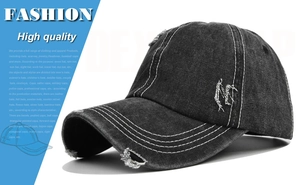 Detail of distressed black washed denim baseball cap with white contrast stitching and M embroidery