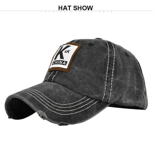 Detailed macro view of vintage dark grey baseball cap showing KK embroidery and distressed brim