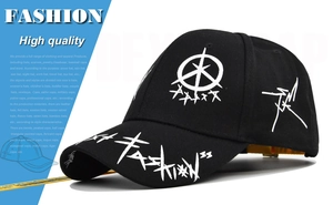 Detail view of black cotton baseball cap with white graffiti print and yellow logo strap