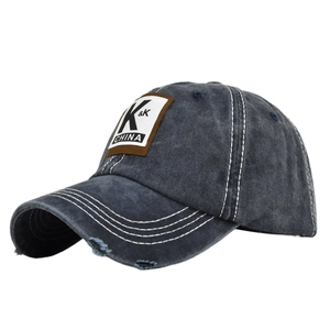 Close-up of vintage washed navy baseball cap with K&K patch and distressed brim details