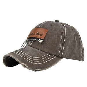 Close-up of distressed charcoal grey baseball cap with metal zipper and leather patch