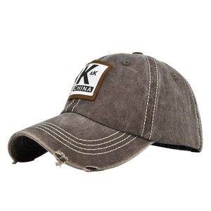 Close-up of vintage grey baseball cap with distressed brim, white stitching and K&K patch