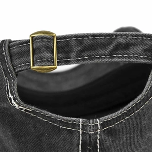 Detail of adjustable brass buckle and white double stitching on black washed denim baseball cap