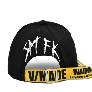 Detail of street-style baseball cap featuring yellow industrial strap and graffiti back