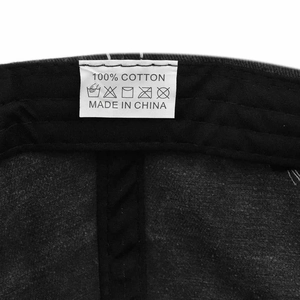 Macro shot of the 100% cotton wash care label and stitching on a black baseball cap