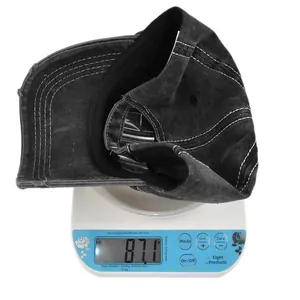 Detail shot of vintage washed grey denim baseball cap weighing 87.1g on a scale