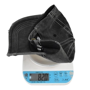 Detailed view of distressed vintage baseball cap on scale showing 82g lightweight design