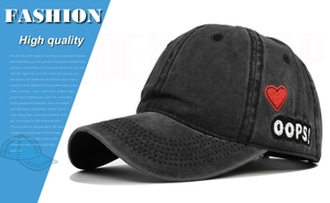 Detailed close-up of red heart embroidery and OOPS! patch on washed baseball cap
