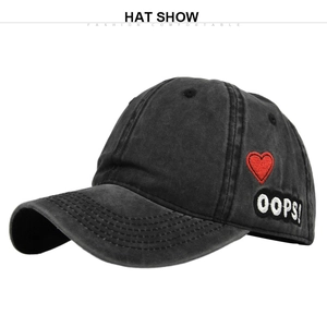 Detailed side view of charcoal grey washed baseball cap with red heart and OOPS embroidery