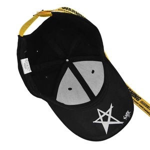 Detailed view of 100% cotton baseball cap label and yellow warning strap on brim