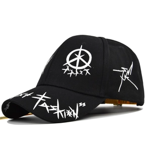 Detail of black baseball cap featuring white graffiti embroidery and yellow adjustable strap