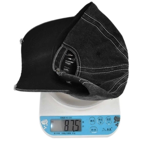 Detailed view of a vintage distressed black denim baseball cap on a scale weighing 87.5g