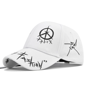 Detail of white cotton baseball cap featuring black graffiti embroidery and street style fashion art