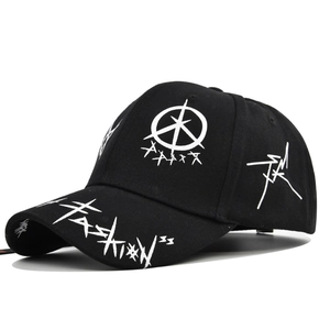 Close-up of graffiti print and Fashion text on the brim of a black baseball cap