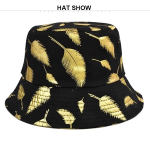 Détail d'un chapeau bob noir avec des motifs de plumes dorées et coutures précises
