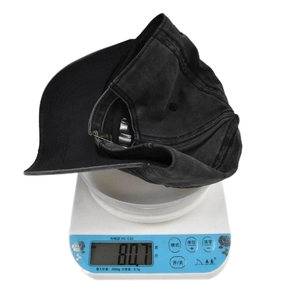 Detail shot showing the 80.7g lightweight measurement of a washed black cotton baseball cap