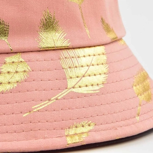 Vue détaillée d'un chapeau bob rose avec motif feuille d'or et surpiqûres de précision