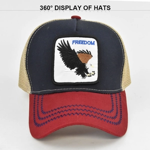 Detail of navy baseball cap with red brim, eagle Freedom patch, and mesh back
