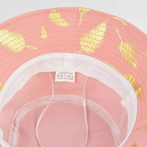 Vue détaillée d'un chapeau bob en coton rose avec imprimé feuille dorée et sangle réglable