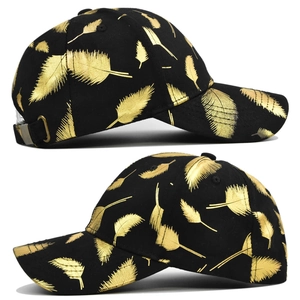 Detail view of black baseball cap with metallic gold feather prints and adjustable strap