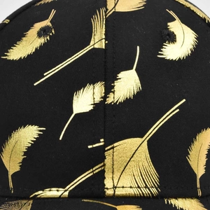 Close-up of black cotton baseball cap showing detailed golden feather prints