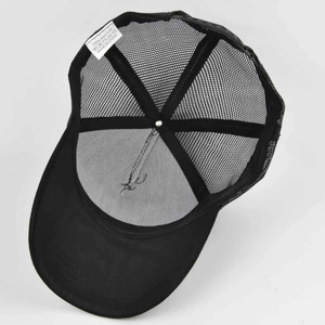 Detail view of the black trucker hat interior showing cotton stitching and mesh texture