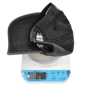 Detail showing the lightweight 84.8g washed cotton vintage style baseball cap on a scale