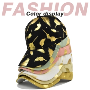 Fashion baseball caps with golden leaf print in multiple colors stacked on white background