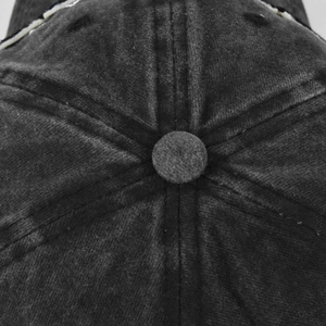 Detailed macro view of the washed cotton baseball cap top button and six-panel stitching
