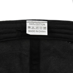 Detail of internal care label on cotton baseball cap showing 100% cotton fabric and icons
