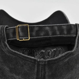Washed black denim baseball cap back view featuring bronze metal buckle adjustment