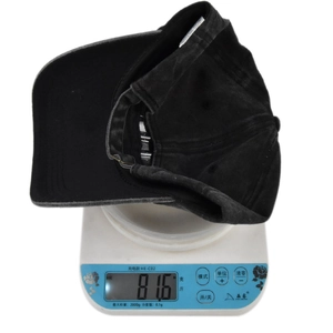 Detailed scale measurement showing the weight of this 100% cotton washed baseball cap