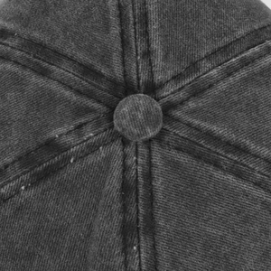 Dettaglio della parte superiore di un cappello da baseball in denim grigio con bottone e cuciture