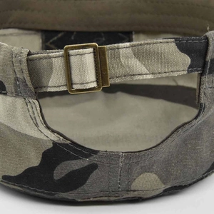 Detail of adjustable metal buckle and camouflage canvas strap on tactical army cap