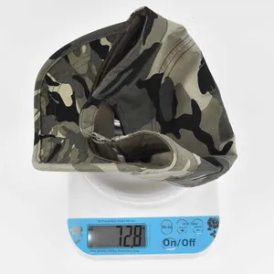 Detailed view of the woodland camo baseball cap being weighed on a digital scale