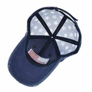 Detail view of American flag patch inside distressed blue mesh trucker baseball cap