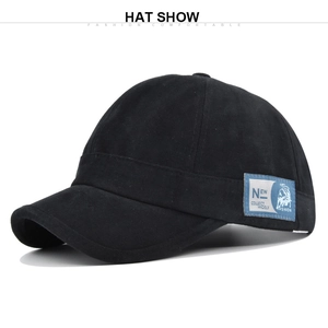 Vue latérale de la casquette noire à bord court avec étiquette bleue et sangle réglable
