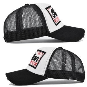 Macro side view of black and white trucker hat featuring mesh back and distressed brim detail