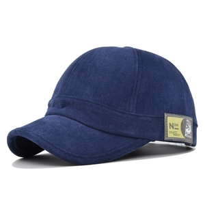 Détail d'une casquette bleue à bord court avec écusson brodé jaune sur le côté