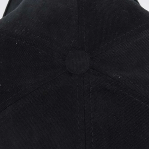 Vue macro détaillée du bouton supérieur et des coutures de la casquette noire en coton